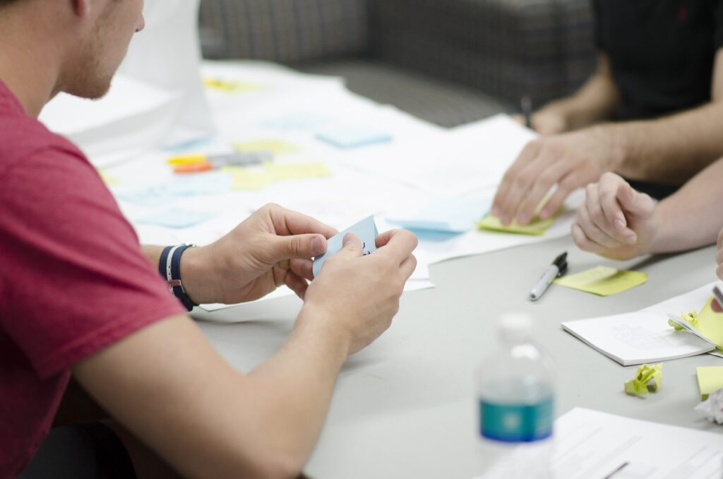team sitting at a table with papers and post-it's